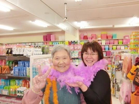 笑顔の2人と多色の商品