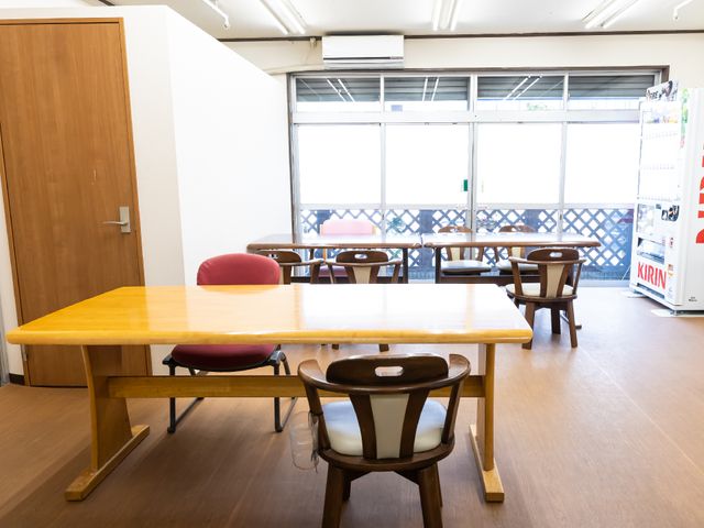 広々とした食堂のテーブルと椅子 共有スペース 落ち着いた色合いの食堂は、ゆったりとした時間を過ごせる空間です。大きなテーブルで、共に食事を楽しむ憩息の場所です。