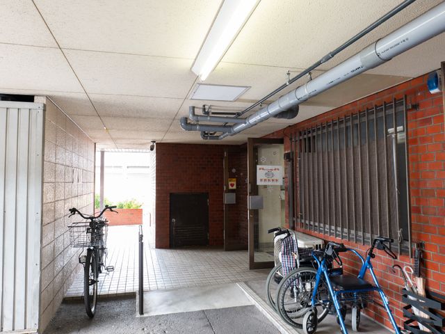 明るいエントランスの風景 玄関 広々とした入口には、自転車が並び、訪れる方々を歓迎しています。スタッフが笑顔でお迎えする、温かな雰囲気のエントランスです。