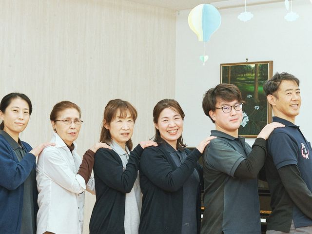 笑顔のスタッフが並ぶ室内 スタッフイメージ 仲の良さが伝わる笑顔のスタッフたちが並んでいます。和やかな雰囲気が魅力的です。