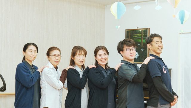 笑顔のスタッフが並ぶ室内