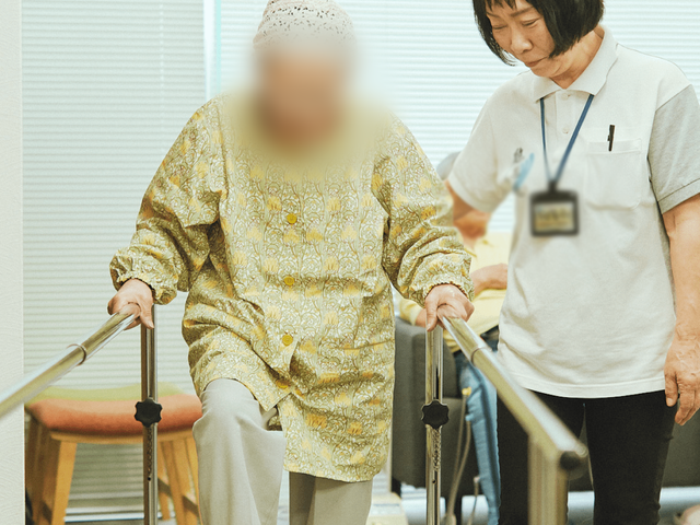 トレーニング中の室内 機能訓練室 安全にサポートされながら、機能訓練に励む姿が見られます。自然光が優しく差し込む空間です。