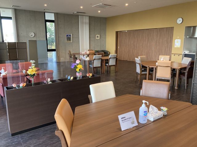 広々としたラウンジ ラウンジ 落ち着いた色合いと自然光が溢れる空間で、ゆったりとした時間を過ごせます。植物が彩りを添えています。