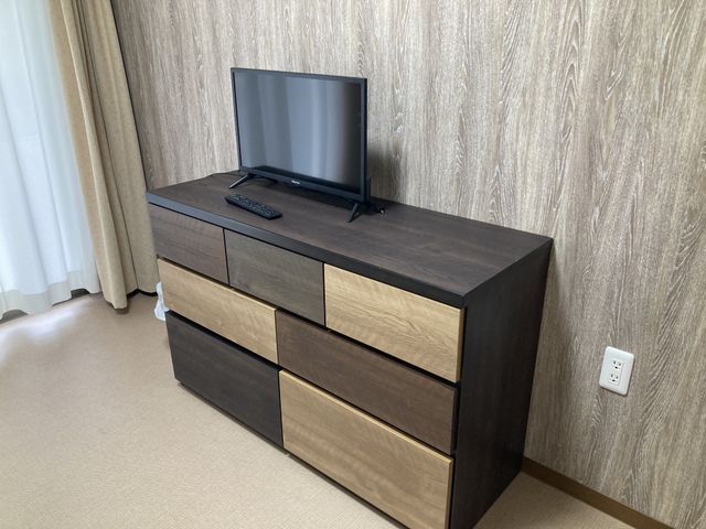 家具とテレビが置かれた居室 居室 ナチュラルな木目調の家具が落ち着いた雰囲気を演出しています。小型テレビが設置されています。