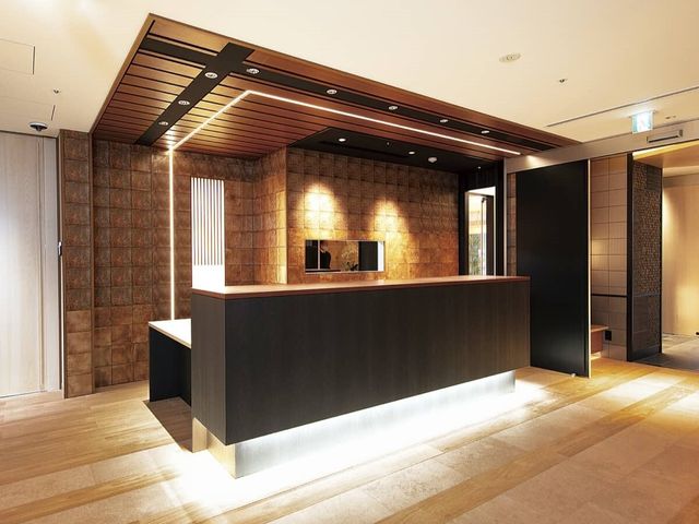 スタイリッシュなフロント 受付 温かみのある照明と木目調のインテリアが特徴的な受付エリアです。初めて訪れる方にも安心の明るい雰囲気を提供しています。