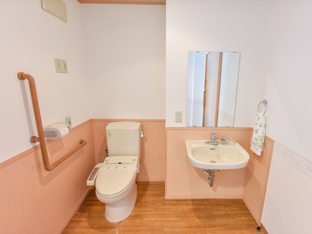 バリアフリートイレ トイレ 安全なサポートが提供される、手すり付きの清潔なトイレです。明るく落ち着いた色合いで、ご利用になる方々にとって使いやすい環境が整っています。
