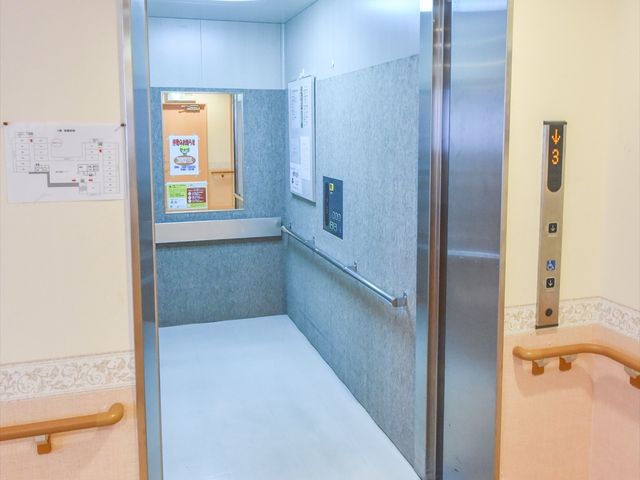 清潔なエレベーター エレベーター 低床のデザインで、ユニバーサルなアクセスを実現しているエレベーターです。手すりも設置され、利用者の移動をサポートしています。