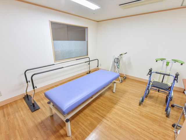 リハビリ用具が置かれた部屋 機能訓練室 広々とした機能訓練室は、日々のリハビリに必要な機器が整っており、安全にトレーニングが行える環境です。