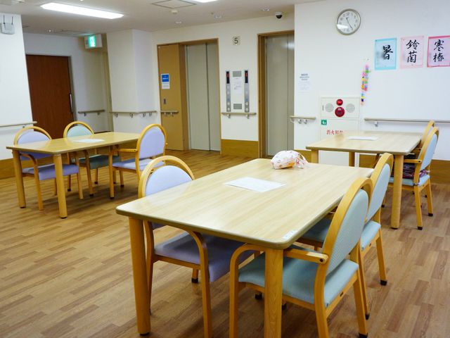 明るい食堂のテーブルと椅子 共有スペース 木製テーブルと椅子が配置された食堂です。静かで落ち着いた雰囲気でお食事を楽しめます。