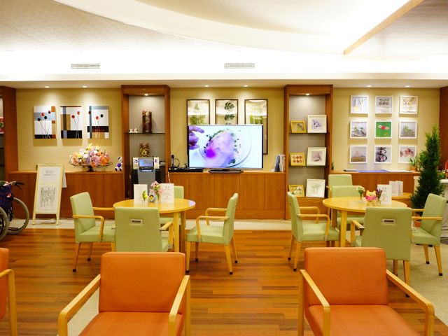 温かみのあるロビーコーナー ロビー３ 明るく開放的なロビーです。テレビを観ながら、お花が飾られたテーブルでコミュニケーションを楽しむことができます。