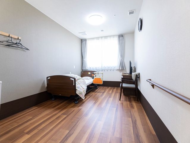ひとり部屋の居室 居室 シンプルで清潔感のある個室です。日の光が差し込む窓と、必要な家具が完備されており、快適な生活空間を提供しています。