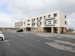 広々駐車場と建物外観