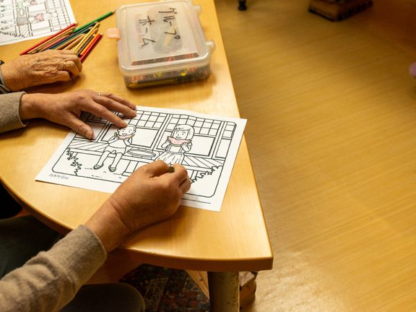 色鉛筆で塗り絵をする手