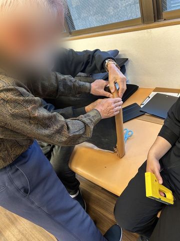 作業する人の手元 ラウンジ 自然な光が差し込む空間で、入居者の方が手作業に取り組んでいます。協力して物を作る楽しさを実感できます。