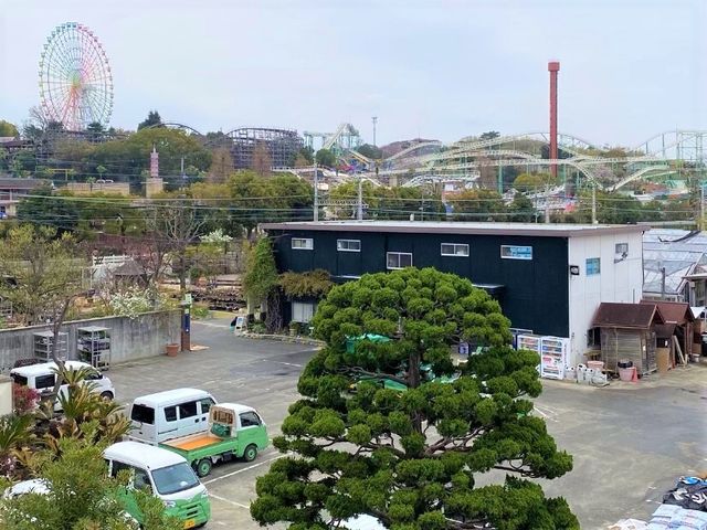 施設前の駐車場と景色 周辺 広々とした駐車スペースが確保された外観です。背後には風景が広がり、開放感に溢れております。