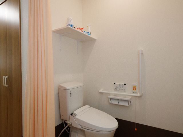 手すり付きトイレ トイレA 手すりが装備された清潔なトイレです。安全に配慮した設計で、使用しやすくなっています。