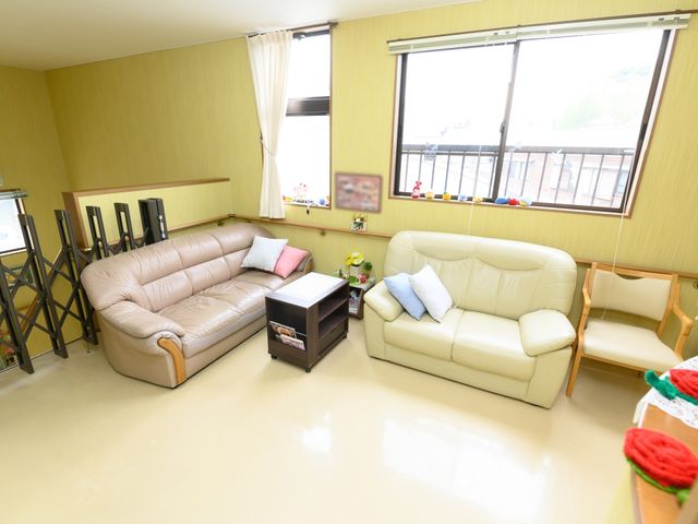 快適な居室の光景 共有スペース ゆったりと配されたソファがある居室です。窓からの自然光が心地よい空間を演出しています。