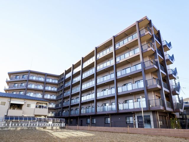 高層建物の外観 外観 広々とした敷地に立つ高層の建物で、各階にバルコニーが備わっています。温かみのあるデザインが魅力です。