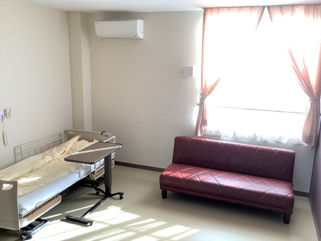 居心地の良い居室 居室 陽光が差し込む居室は、ゆったりとしたソファが配置され、リラックスした時間を過ごすことができます。ベッドの横には移動しやすいサイドテーブルがあります。