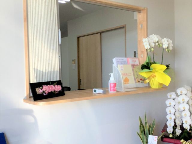 受付と花のある空間 玄関 明るく清潔感があり、美しい花がお出迎えする受付です。毎日の業務に活気を与える心地よい環境が整っています。