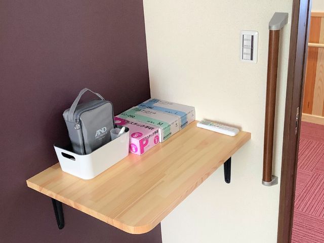 廊下の壁面棚とグッズ 居室 廊下に備え付けられた壁面棚は、スリッパや手袋などの日用品を整理して収納できる便利なスペースです。