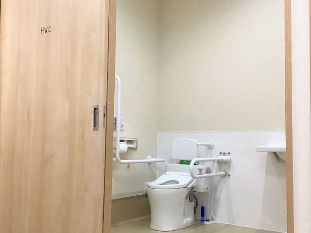 バリアフリートイレの入口 トイレ 手すり付きで安心のトイレスペース。車椅子の方も利用しやすく、快適な環境が整っています。