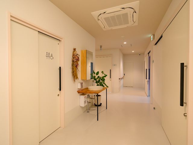 明るい共用廊下 廊下 ゆったりとした通行スペースがあり、壁にはアートが飾られています。バリアフリーを考慮した設計で、心地よい職場環境が整っています。