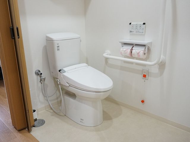 手すり付きトイレの様子 トイレ 安全な手すりと広々としたスペースで、快適なトイレの使用ができるように設計されています。緊急時には呼び出しボタンをご使用いただけます。