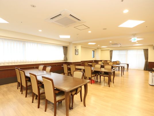 大きな窓のある食堂で、とても明るい。通路も広く、手すりも付いていて安心。大勢集まるので空気清浄機も設置してある。