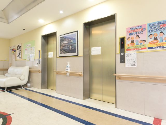 快適な施設のエントランス エレベーター周辺 清潔で広々とした受付エリアが、訪れる方々をあたたかく迎え入れています。明るく開放的な雰囲気の空間で、ご家族も安心して来訪できる環境を整えています。