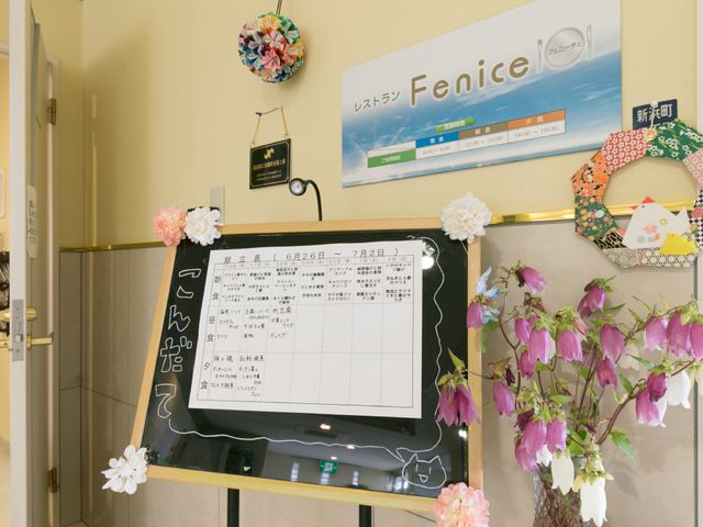 活動案内と装飾の掲示物 レストラン入り口 手作りの装飾がある掲示スペースです。日々の予定表と共に、温かみのある雰囲気を感じていただけます。