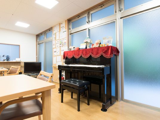 網入りガラスの全面採光の取れる多目的室。ピアノが設置してあり入居者の方などのレクリエーションなど交流の場である。