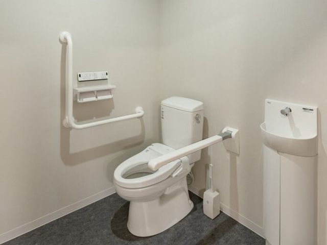 バリアフリー対応トイレ トイレ 安全で快適な使い心地を追求したバリアフリー設計のトイレです。利用者の日々の暮らしをサポートするため、手すりを設けた設備が整っています。