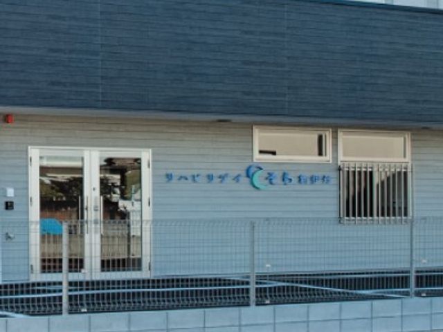 看板前の外観 外観 シンプルで親しみやすいデザインです。施設の名前が入り口に掲げられています。