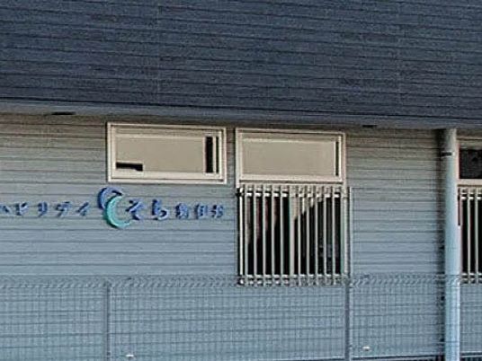 施設外観の看板と窓が見える外観  
