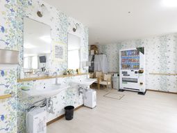 明るい壁紙の洗面台エリア