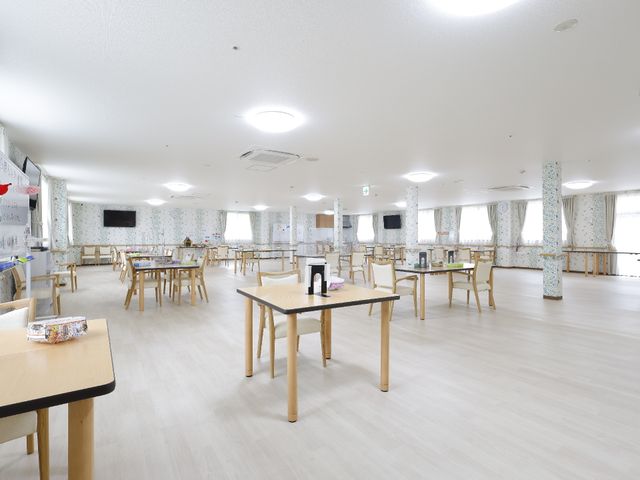 明るい広々とした食堂 広くて明るい食堂です。木製のテーブルと椅子が並び、コミュニケーションを大切にした配置になっており、職員と利用者の交流の場にもなっています。