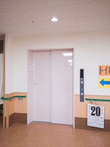 バリアフリーなエレベーター入口 エレベーター 手すり付きで安全に配慮されたエレベーター入口です。利用者の移動のしやすさを考えた設計になっています。
