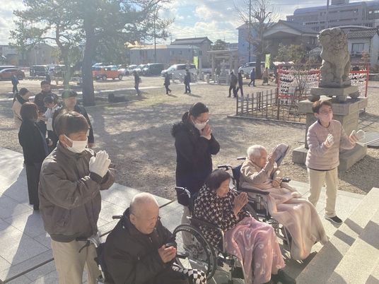 祈る入居者とスタッフ