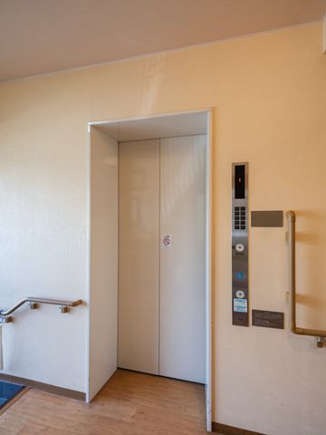 清潔なエレベーターホール エレベーター スムーズに行き来できる清潔感のあるエレベーターです。手すりが付いており、安全にご利用いただけます。