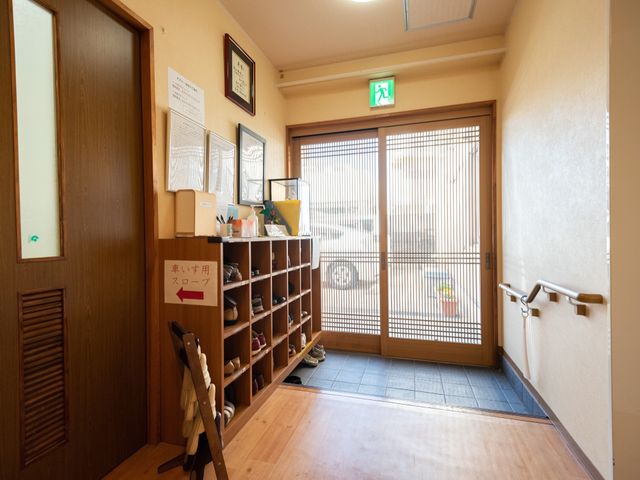 玄関の明るい通路 エントランス 整理された靴箱があり、出入りしやすい広々としたエントランスです。手すりがついており、安全に歩けるよう配慮されています。