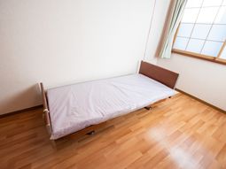 シンプルなベッドと窓の居室
