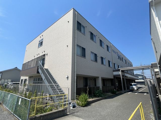 空を背景にした建物外観 外観 清潔感のある建物で、日中は外からの光がよく入ります。職場環境として安心できる雰囲気です。