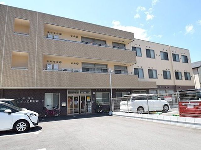 入口が明るい建物 外観 ガラス扉を通して日差しが差し込むエントランスは、訪れる人々に温かみを感じさせます。駐車場が広々としていて、アクセスも良好です。
