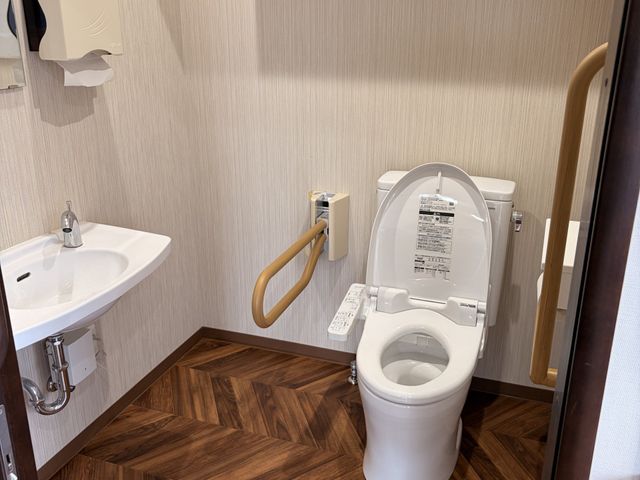 手すり付きトイレ トイレ   手すりが複数あり、立ち座りを支えやすいトイレです。手洗い器も近く、動線が短く使いやすそうです。