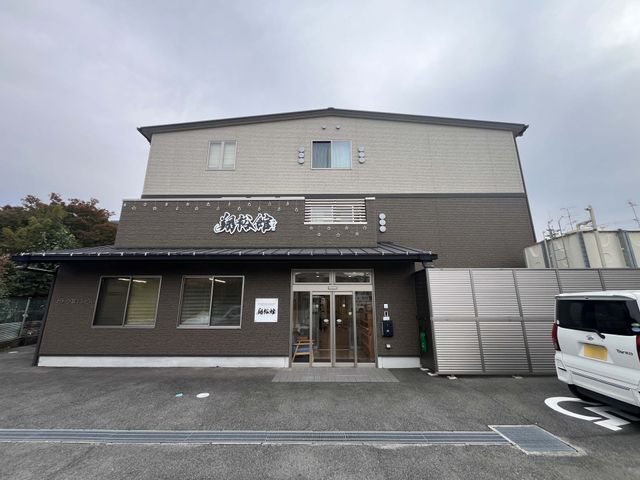 木製の入り口 外観 落ち着いたデザインの建物の入り口があり、訪れる人に安心感を与えます。