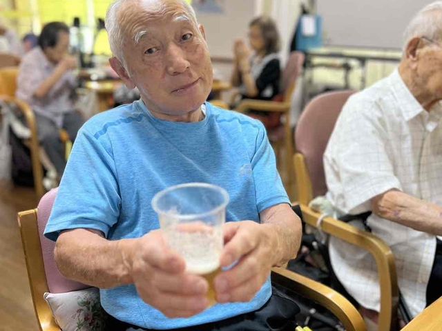 楽しそうに過ごす人々がいる室内 ダイニングルーム みんなで食事を楽しめる広々とした空間です。和やかな時間を共有し、リラックスできます。