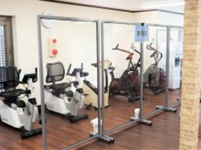 運動器具が並ぶ室内 ジム 仕切りで区切られた運動スペースで、安全にトレーニングができます。快適な環境で体を動かせます。
