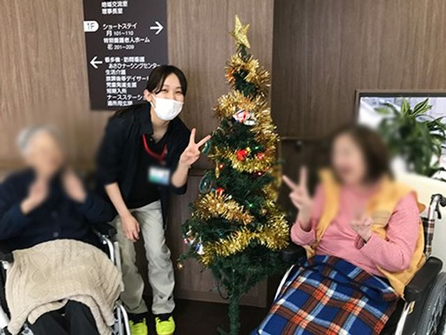 クリスマスツリーと笑顔のスタッフ