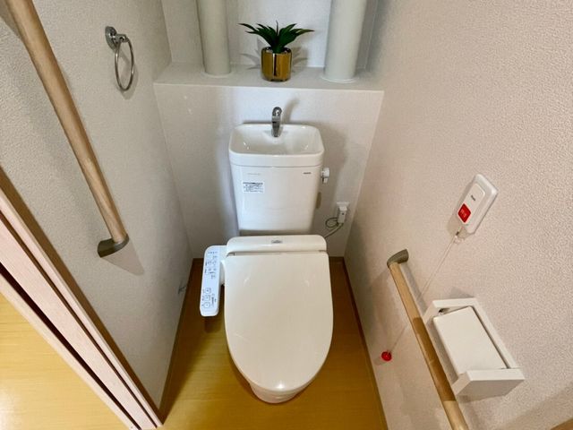 清潔感のあるトイレ空間 居室トイレ 手すりと緊急呼び出しボタンが備わった安心感のあるトイレです。利用者の自立支援に配慮した設計となっております。